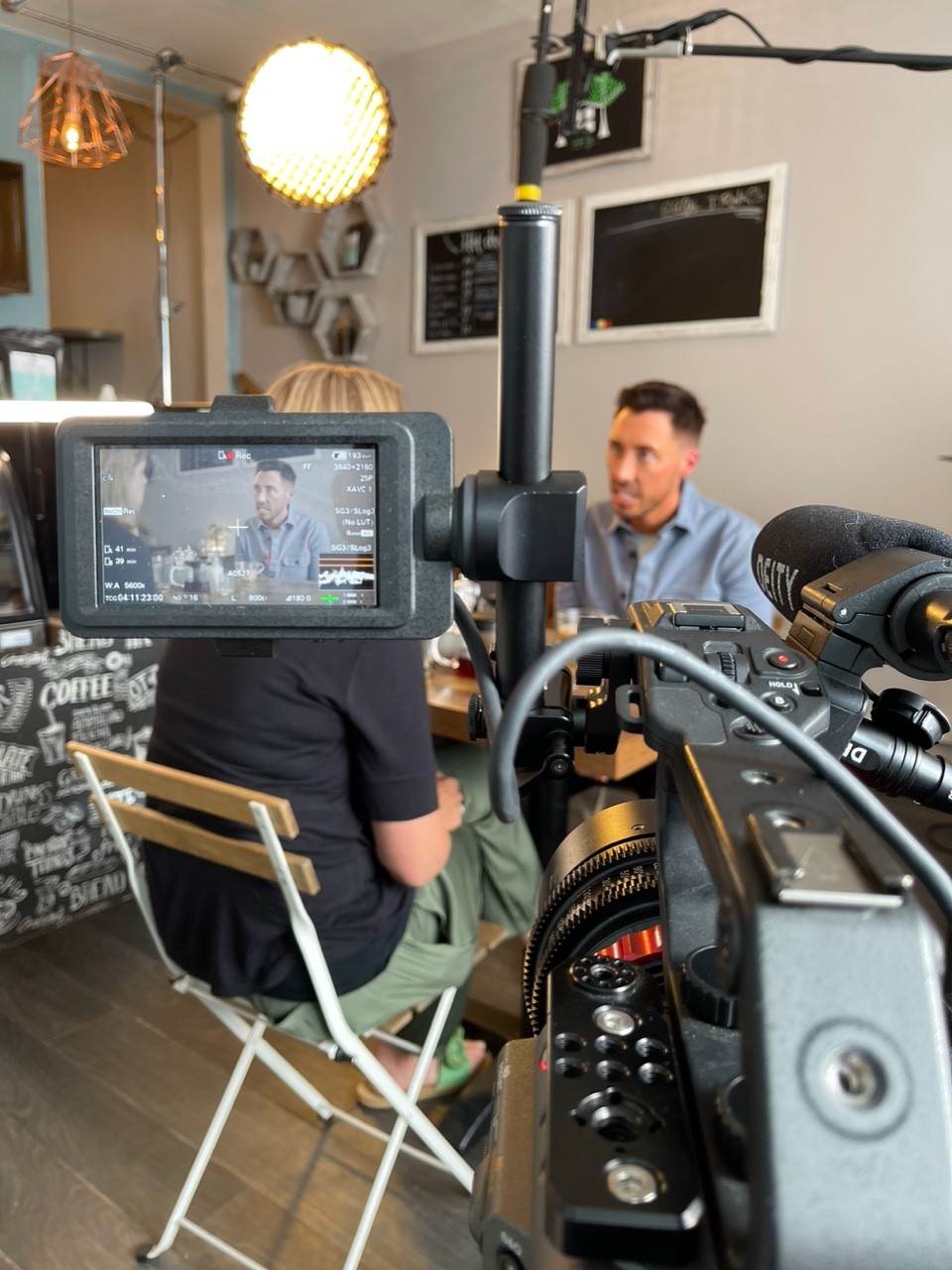 Ross interviews a parent who adopted a child. The film set-up is shown.